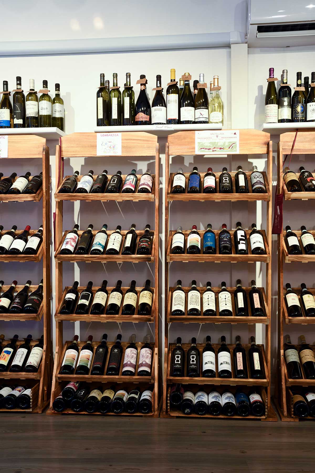 Scaffali dei vini rossi lombardi della Valtellina nell'enoteca di Bellagio