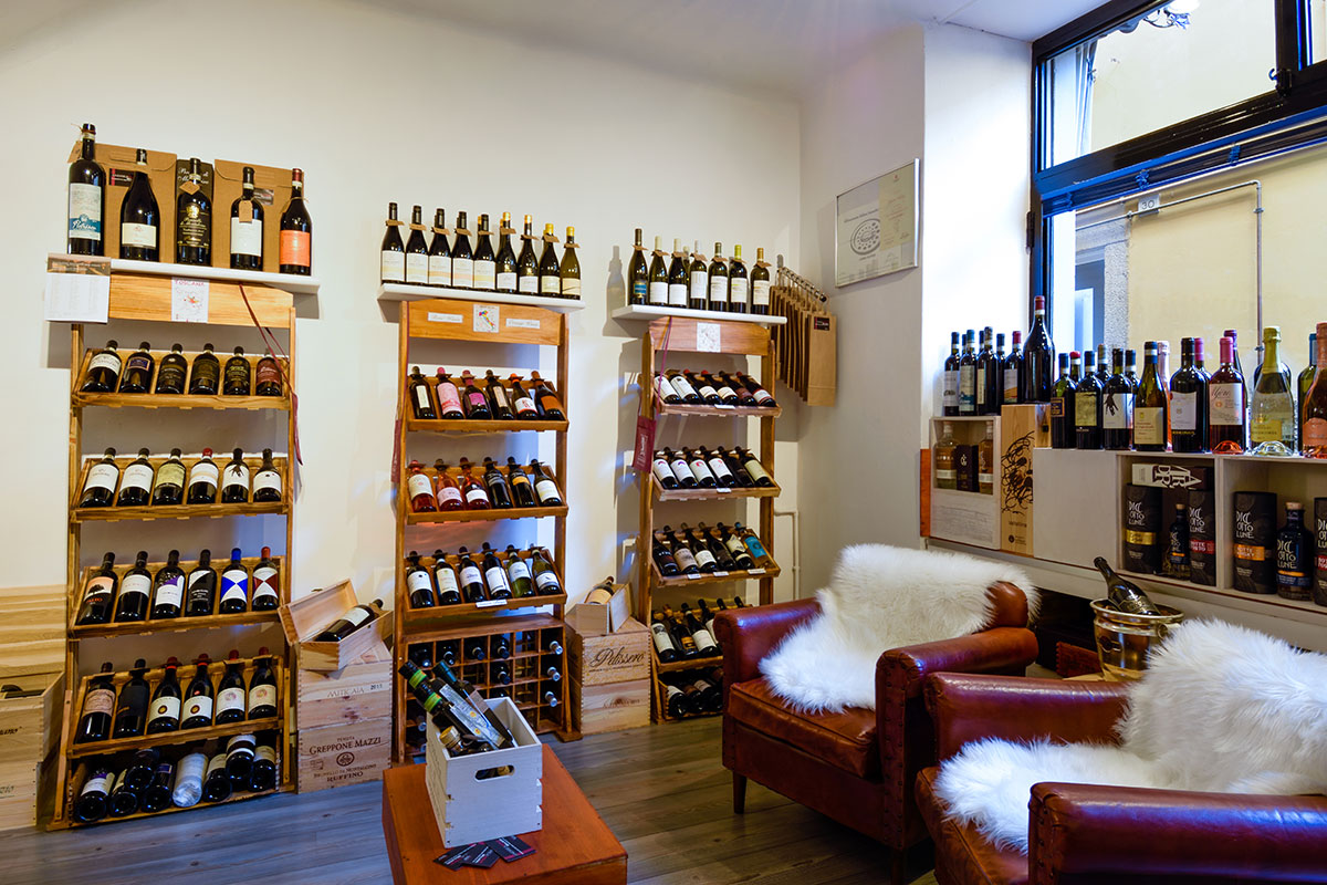 Scaffali in legno e poltrone con pelliccia nell'enoteca di Bellagio